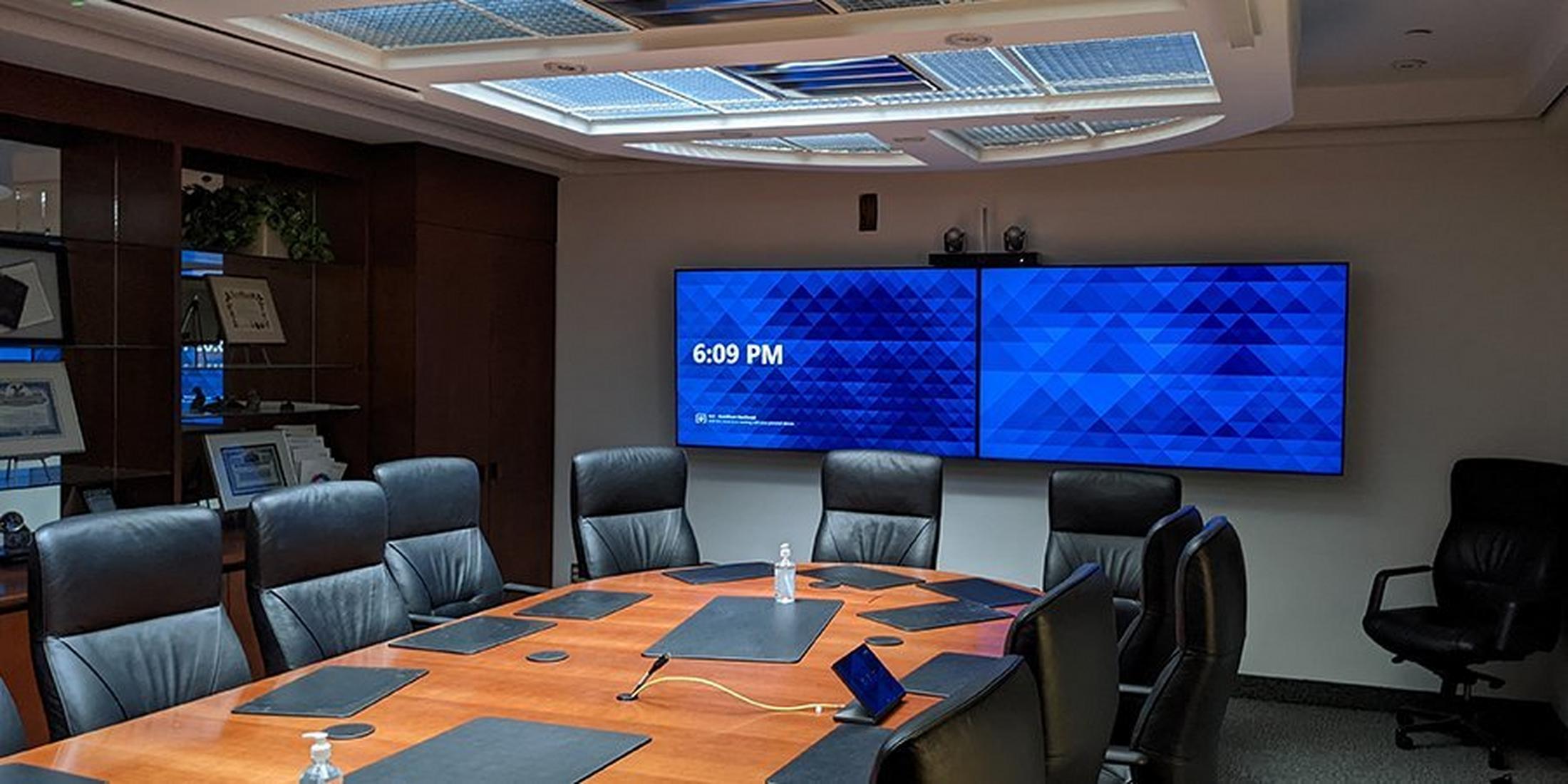a conference room with a large table and chairs and a large flat screen tv